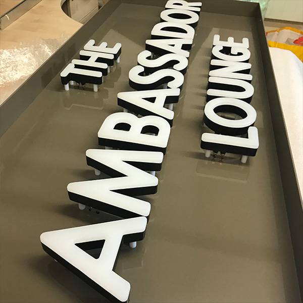 faux neon sign The Ambassador Lounge white