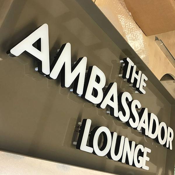 faux neon sign The Ambassador Lounge white