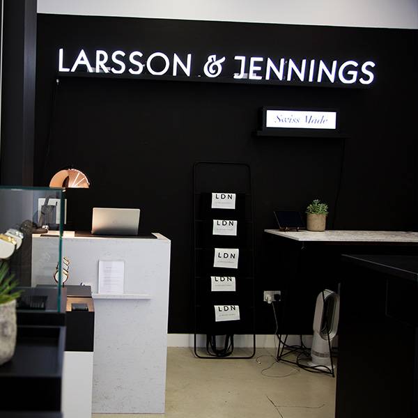 Faux neon sign white Larsson Jennings logo