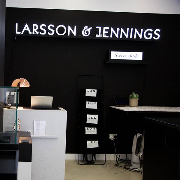Faux neon sign white Larsson Jennings logo