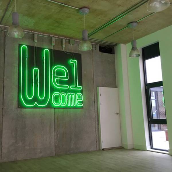 Welcome neon sign on concrete